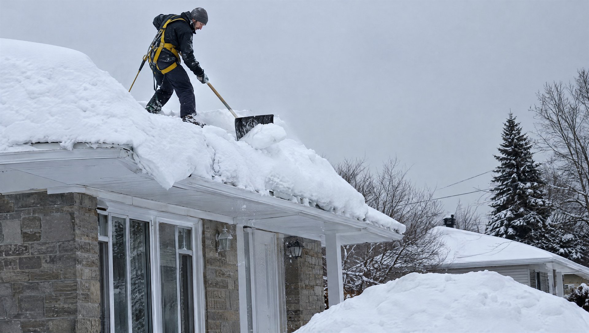 Déneigement d'une toiture de bungalow